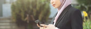 سيدة أعمال مع هاتفها المحمول باستخدام الخدمات المصرفية عبر الهاتف المحمول