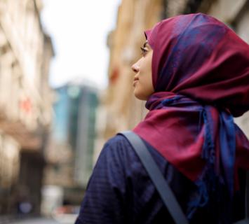 Woman in a red and blue hijab walking through the street