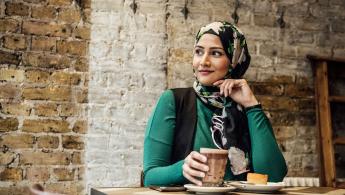 Woman sitting down drinking a coffee