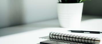 Notepad and phone on a white desk
