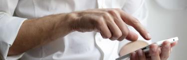 Man in white shirt tapping mobile screen