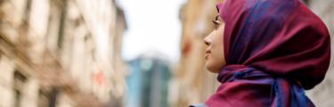 Woman in a red and blue hijab walking through the street