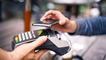صورة مقربة لشخص يدفع في مبنى البيع بالتجزئة باستخدام Aman Pay QR