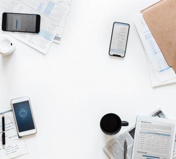 White desk with documents and phones