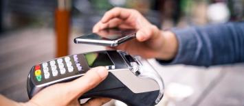 Close up of Person Paying at retail terminal using Aman Pay QR
