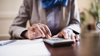 Woman using a calculator sitting at a desk