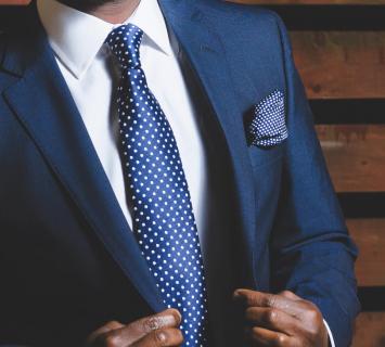 Close up of a man wearing a navy suit