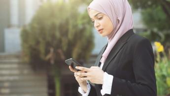 Business woman looking at her mobile phone using mobile banking services