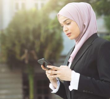 Business woman looking at her mobile phone using mobile banking services